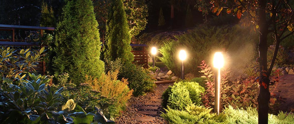 Custom outdoor lighting installed along a lush landscape walkway in Saylorville, IA.